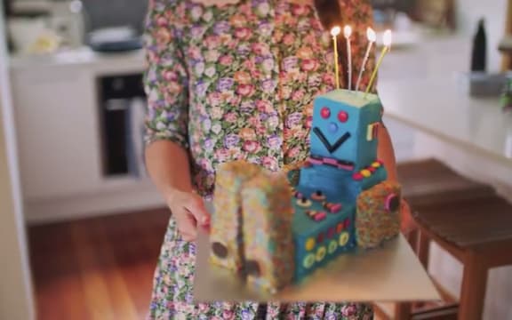 Woman holding children's birthday cake.