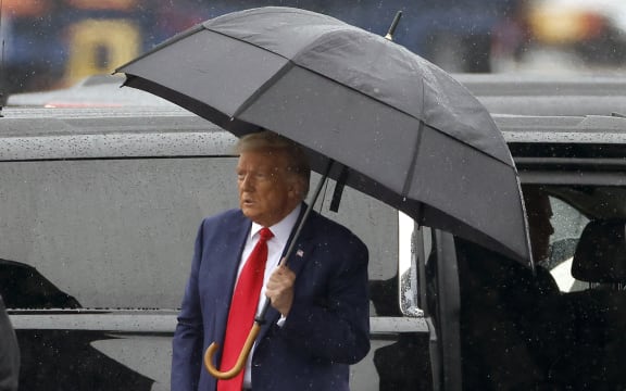 ARLINGTON, VIRGINIA - AUGUST 03: Former U.S. President Donald Trump holds an umbrella as he arrives at Reagan National Airport following an arraignment in a Washington, D.C. court on August 3, 2023 in Arlington, Virginia. Former U.S. President Donald Trump pleaded not guilty to four felony criminal charges during his arraignment this afternoon after being indicted for his alleged efforts to overturn the 2020 election.   Tasos Katopodis/Getty Images/AFP (Photo by TASOS KATOPODIS / GETTY IMAGES NORTH AMERICA / Getty Images via AFP)