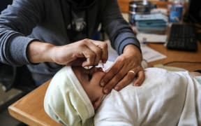 A UNRWA employee is providing a Polio vaccine in a clinic in Deir al-Balah, central Gaza Strip, on January 21, 2024, amid ongoing battles between Israel and the Palestinian militant group Hamas.