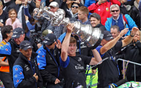 Team NZ helmsman Peter Burling holds the America's Cup high at the Auckland parade.