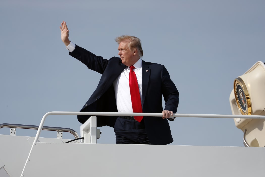 President Donald Trump waves while boarding Air Force One.