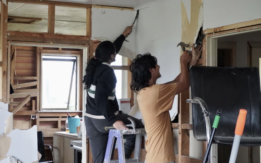Apprentices removing gib from a flood-damaged home on Ruataniwha Road.