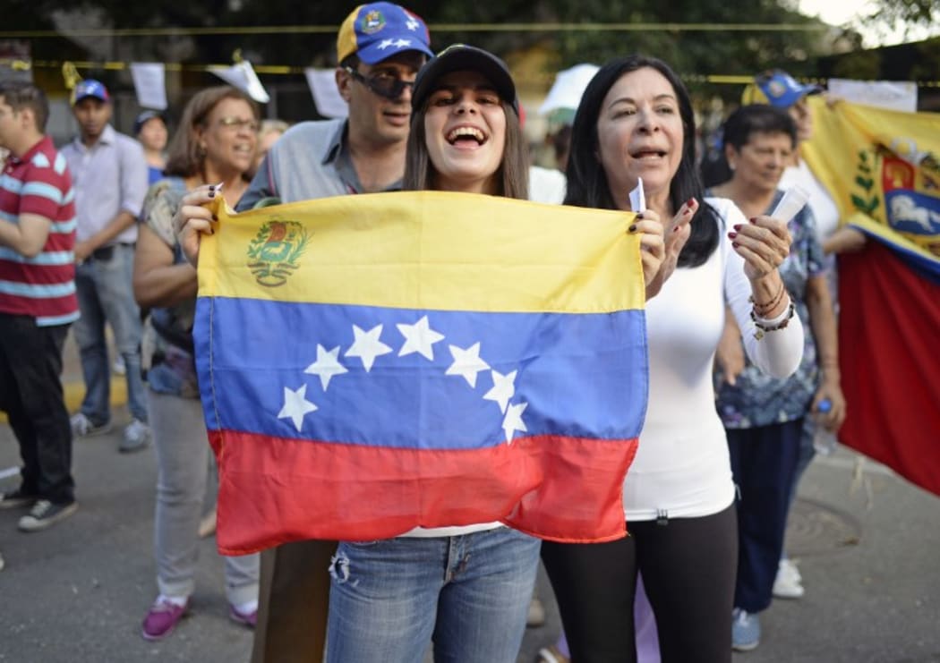Opposition activists celebrate outside polling stations after taking part in an opposition-organized vote to measure public support for Venezuelan President Nicolas Maduro's plan to rewrite the constitution.