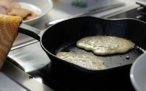 Pancakes being cooked on cast iron pan.