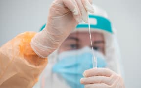 A medical worker poses with a swab testing kit at the laboratory and testing centre for Covid-19 antigen testing of hauliers bound for France via Dublin Port, at Dublin Airport