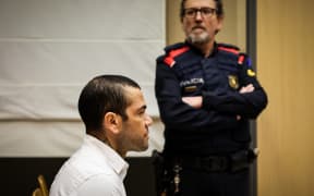 Brazilian footballer Dani Alves looks on at the start of his trial at the High Court of Justice of Catalonia in Barcelona, on February 5, 2024. Brazilian footballer Dani Alves, a former star at Barca and PSG, goes on trial in Barcelona accused of raping a woman in a local nightclub. Prosecutors are asking for a nine-year prison sentence, followed by 10 years of conditional liberty. They are also asking he pay 150,000 euros ($162,000) in compensation to the woman. (Photo by Jordi BORRAS / POOL / AFP)