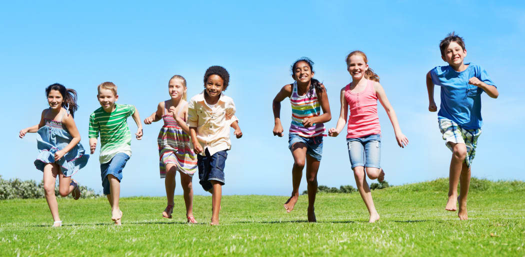 A group of kids running outside