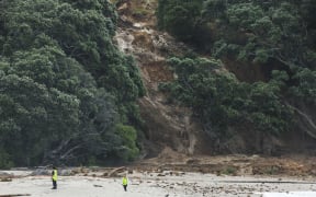 A general view shows a landslide while a search is underway by local emergency services for missing people at Mount Maunganui in Tauranga on January 22, 2026. A landslide smashed into a campsite in rain-swept northern New Zealand leaving multiple people missing, police and rescuers said. (Photo by DJ MILLS / AFP)