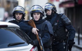 Armed police stand guard after  knife-wielding man was shot dead on the anniversary of the Charlie Hebdo attacks.