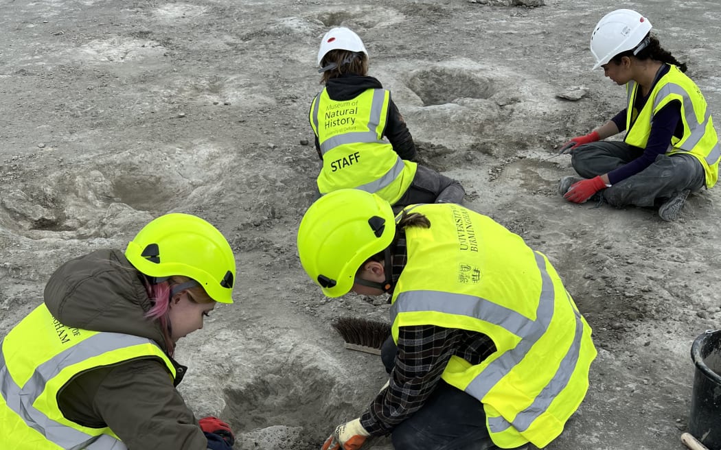 A handout photograph taken by vertebrate palaeontologist, Dr Emma Nicholls, and released by the Oxford University of Natural History on January 2, 2025 shows members of the excavation team working on the footprints at the Dewars Farm Quarry, north of Oxford in central England on June 17, 2024. - Nearly 200 dinosaur footprints were discovered this summer in a quarry in Oxfordshire, an exceptional site among the largest in the entire country, the universities of Oxford and Birmingham announced on Thursday, January 2, 2024. (Photo by Emma NICHOLLS / Oxford University Museum of Natural History / AFP) / RESTRICTED TO EDITORIAL USE - MANDATORY CREDIT "AFP PHOTO / EMMA NICHOLLS / OXFORD UNIVERSITY MUSEUM OF NATURAL HISTORY  " - NO MARKETING NO ADVERTISING CAMPAIGNS - DISTRIBUTED AS A SERVICE TO CLIENTS