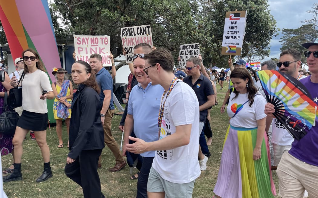 Christopher Luxon and Nicola Willison are surrounded by protesters at the Big Gay Out