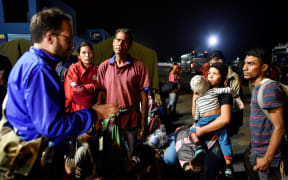 An official of UNHCR speaks with Venezuelan migrants on August 25, 2018, upon their arrival in Huaquillas.