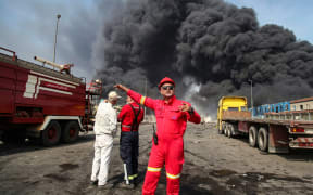 Thick, black smoke rises as rescuers arrive near the source of an explosion at the Shahid Rajaee port dock southwest of Bandar Abbas in the Iranian province of Hormozgan on April 26, 2025. Several containers exploded on April 26 at Iran's largest commercial port, authorities said, causing a major blast and fire, and leaving hundreds injured. Shahid Rajaee, more than 1,000 kilometres (620 miles) south of the capital, is the most advanced container port in Iran, according to the official IRNA news agency. (Photo by MOHAMMAD RASOLE  MORADI / IRNA / AFP)