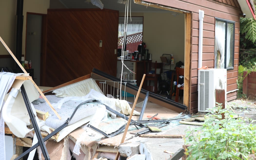 Two homes were damaged after a car left Don Buck Road and drove down a bank, through the lounge of one property and ended up in the bedroom of a neighbouring one.
