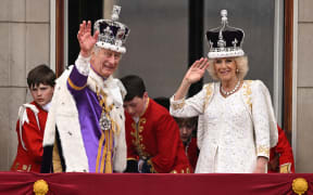 Britain's King Charles III wearing the Imperial state Crown, and Britain's Queen Camilla wearing a modified version of Queen Mary's Crown wave from the Buckingham Palace balcony after viewing the Royal Air Force fly-past in central London on May 6, 2023, after their coronations. - The set-piece coronation is the first in Britain in 70 years, and only the second in history to be televised. Charles will be the 40th reigning monarch to be crowned at the central London church since King William I in 1066. (Photo by Oli SCARFF / AFP)