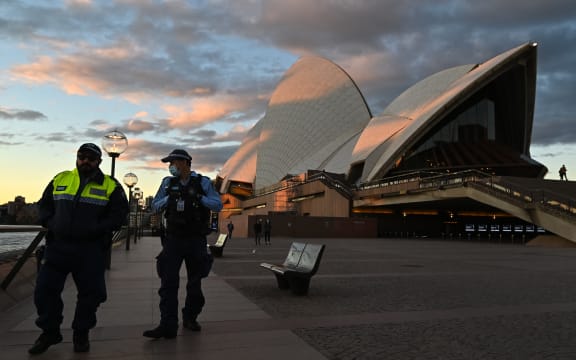 Police officers walk past The Sydney Opera House during the first day of lockdown in Sydney, Australia.