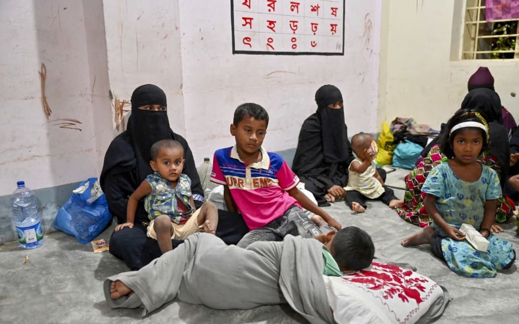 Women take shelter with their children in Shahpori island on the outskirts of Teknaf, on May 13, 2023, ahead of Cyclone Mocha's landfall. Thousands fled Myanmar's west coast and officials in neighbouring Bangladesh raced to evacuate Rohingya refugees on May 13 as the most powerful cyclone in the region for over a decade churned across the Bay of Bengal. (Photo by )