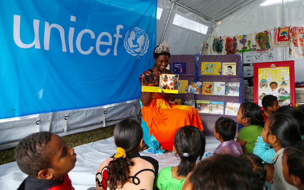 The Reigning Miss Hibiscus 2015, Marie Fall, takes part in a special reading with children of the newly launched locally produced children’s story books.