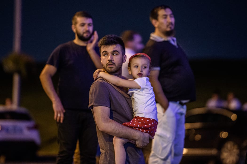 People leave Ataturk Airport after  explosions outside the arrivals hall.