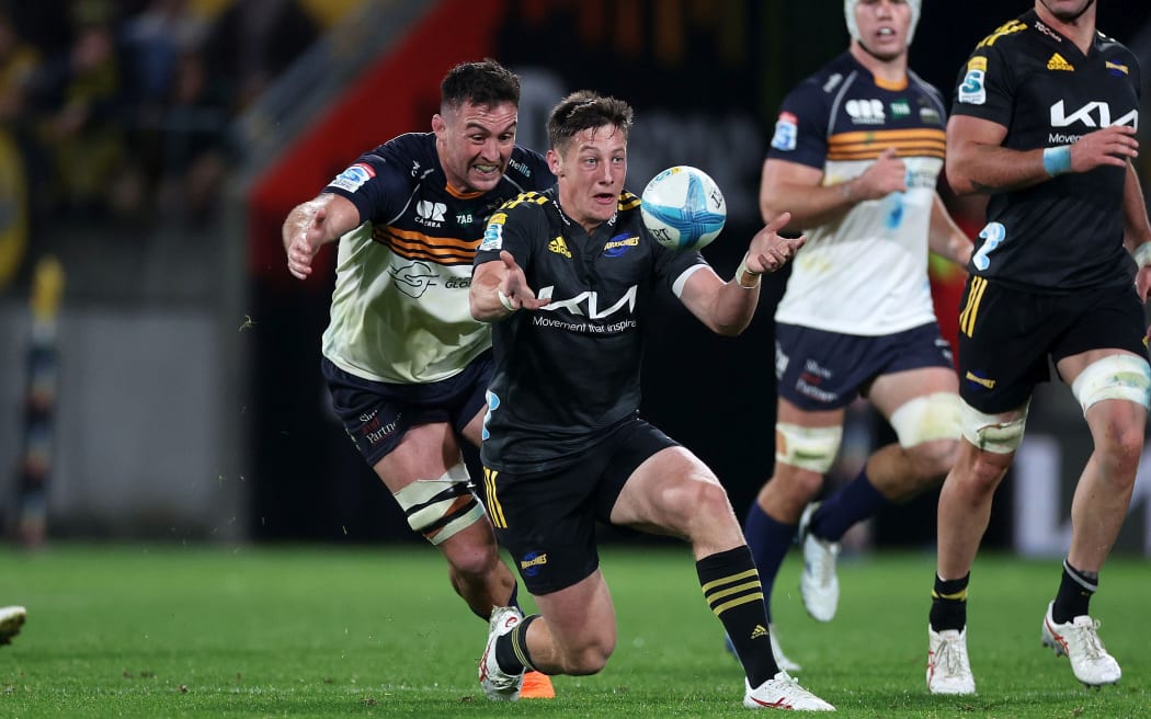 Hurricanes halfback Cameron Roigard clears the ball under pressure.
