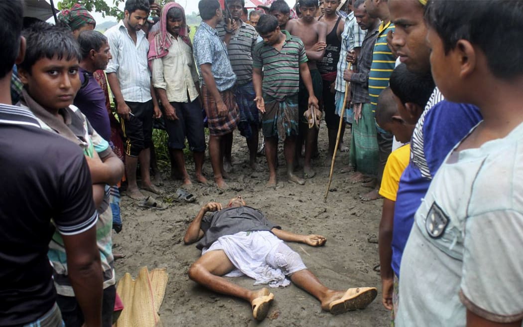 People gather around the body of Hindu priest Ananda Gopal Ganguly in Jhenidah, Bangladesh.