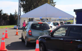 Cars line up as people wait to get vaccinated.
