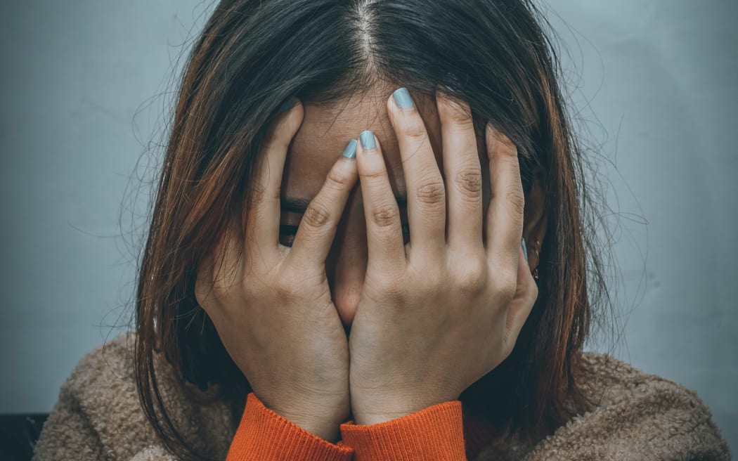 teenage girl with hands over face