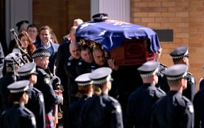 The coffin of police officer Senior Constable Vadim de Waart-Hottart is carried from from the Victoria Police Academy chapel following his funeral service in Melbourne on September 5, 2025. Around a thousand people have gathered for a funeral of de Waart-Hottart, one of two Victoria Police officers killed in a shooting at Porepunkah in Victoria's north-east last week. Suspected gunman Dezi Freeman fled into dense bushland on foot, sparking an enormous manhunt involving hundreds of police officers that is now in its eleventh day. (Photo by William WEST / AFP)