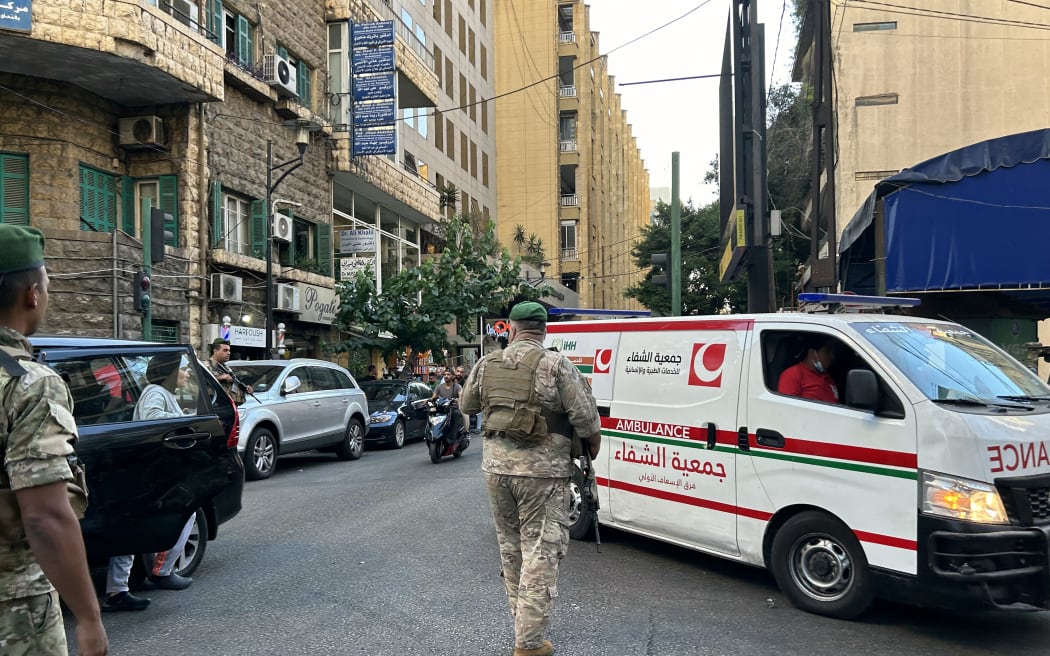 Lebanese army soldiers stand guard as an ambulance rushes wounded people to a hospital in Beirut on September 17, 2024, after explosions hit locations in several Hezbollah strongholds around Lebanon amid ongoing cross-border tensions between Israel and Hezbollah fighters.