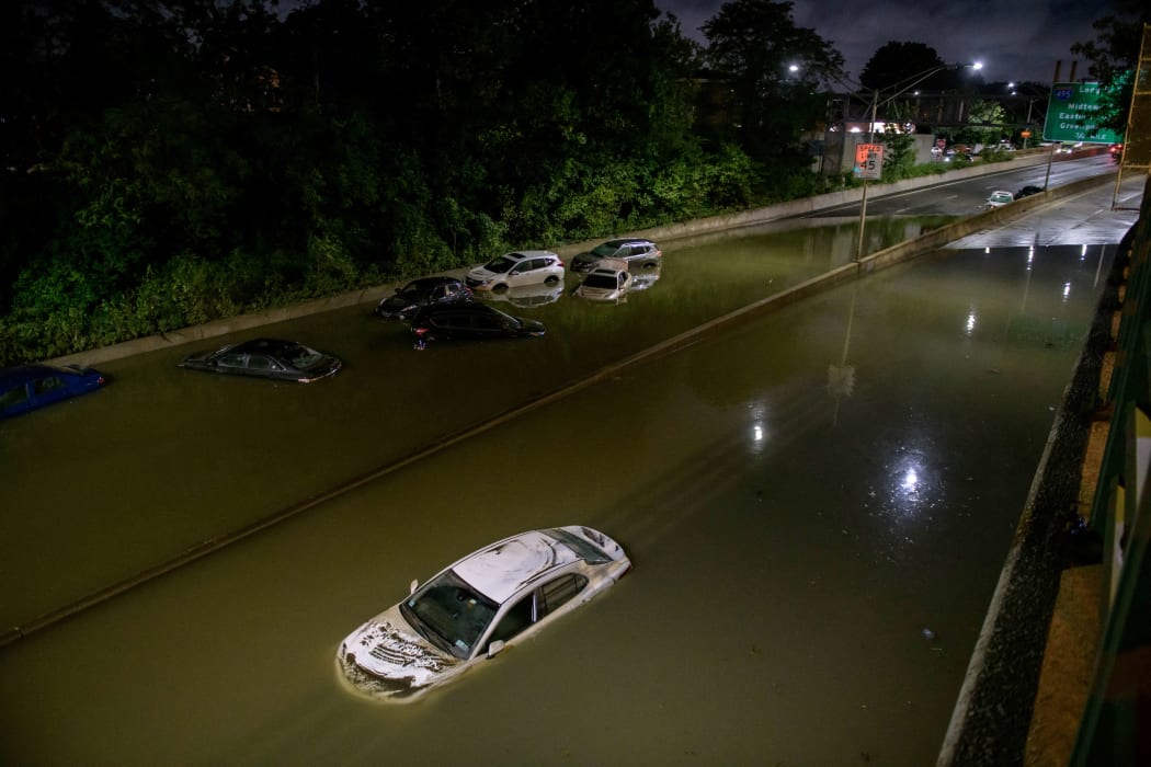 Floodwater surrounds vehicles following heavy rain on an expressway in Brooklyn, New York