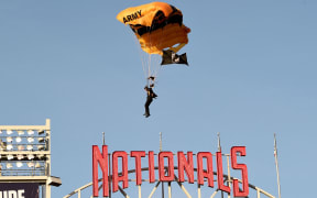 WASHINGTON, DC - APRIL 20: A member of the US Army Parachute Team The Golden Knights lands at Nationals Park before the game between the Washington Nationals and the Arizona Diamondbacks on April 20, 2022 in Washington, DC.