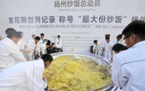A group of 300 people teamed up to cook four tonnes of fried rice in Yangzhou in China's eastern province of Jiangsu on 22 October 2015.
