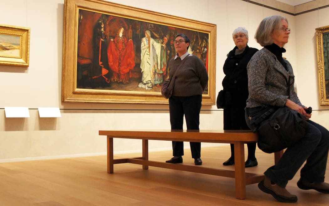 Patrons inside an art gallery, looking at the art.