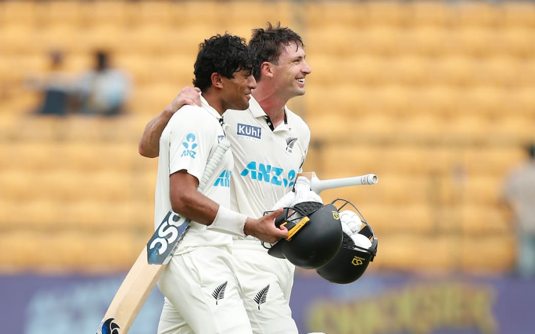 Rachin Ravindra of New Zealand and Will Young walk off the pitch after defeating India by eight wickets in Bengaluru. 2024.