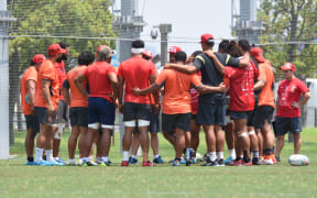 The 'Ikale Tahi players huddle together during training in Japan.