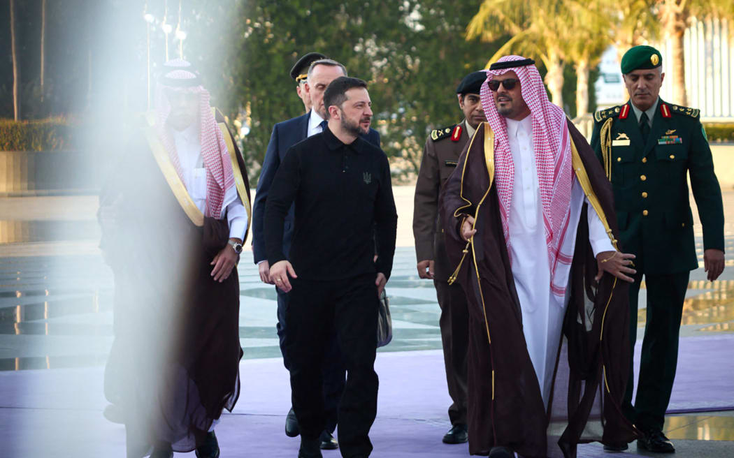 In this handout photograph taken and released by the Ukrainian Presidential Press Service on 10 March, 2025, Ukraine's President Volodymyr Zelensky (C-L) is welcomed by Deputy Governor of Makkah Region Prince Saud bin Mishal bin Abdulaziz (C-R) upon his arrival to Jeddah for talks between Ukrainian officials, Saudi and US representatives.