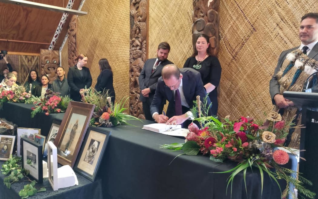 Andrew Little, centre, initialling Te Ruruku Pūtakerongo.