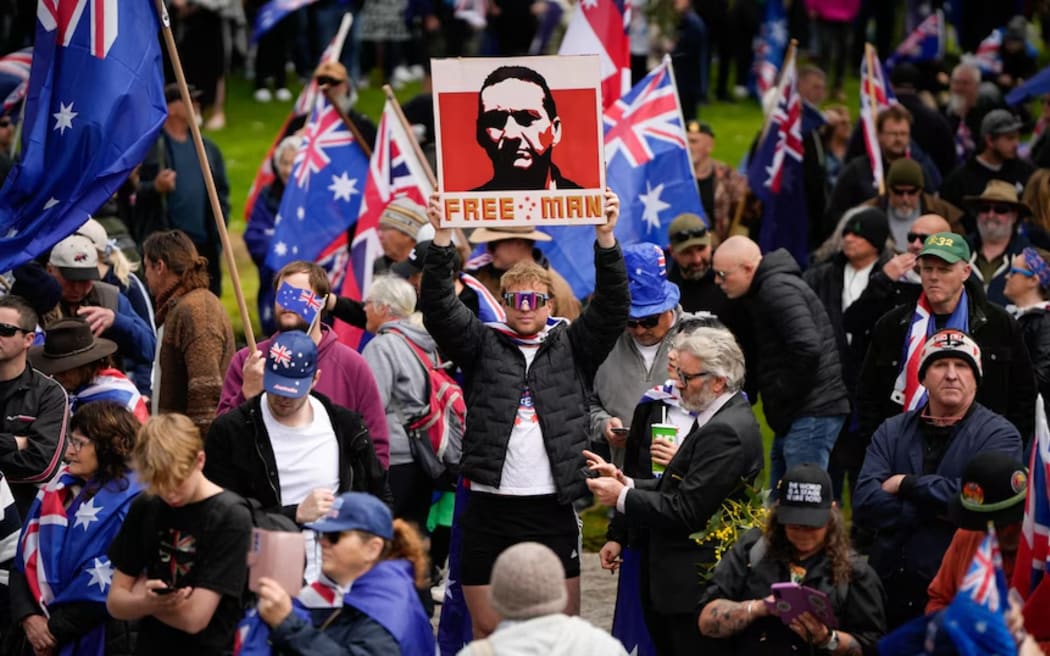 A protester at the Adelaide March for Australia rally holds up a photo of alleged police shooter and fugitive Dezi Freeman.