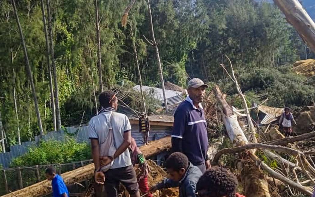 People gather at the site of a landslide in Maip Mulitaka in Papua New Guinea's Enga Province on May 24, 2024. Local officials and aid groups said a massive landslide struck a village in Papua New Guinea's highlands on May 24, with many feared dead.
