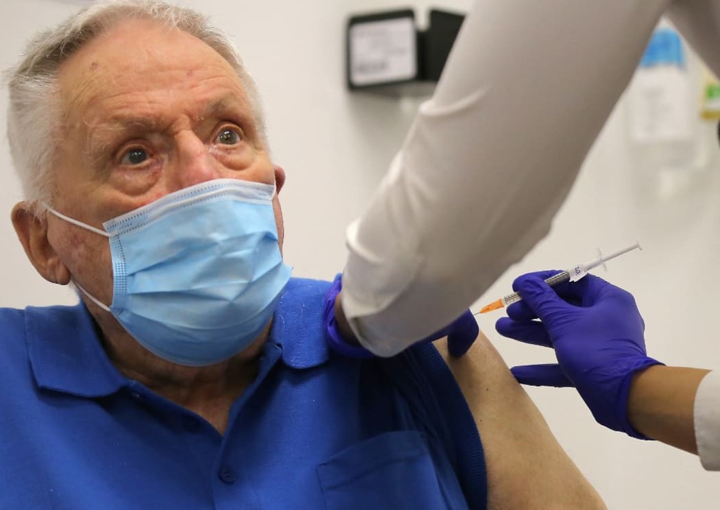 John Healy, a resident of the Wesley Taylor aged care facility, becomes the second person in Australia to receive a dose of the Pfizer/BioNTech Covid-19 vaccine at the Castle Hill Medical Centre in Sydney on February 21, 2021. (Photo by STEVEN SAPHORE / AFP)