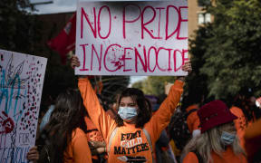 A woman holds a placard during the "Every Child Matters" march to mark the first National Day for Truth and Reconciliation in Montreal, Canada on September 30, 2021.