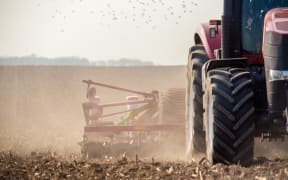 The tractor harvester working on the field