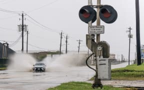 A car speeds through a flooded street ahead of the Tropical Storm Nicholas on September in Galveston, Texas.