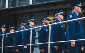 Police officers observe a minute of silence to remember Constable Matthew Hunt at the Memorial Wall in Wellington.