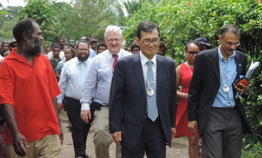Dr Albert Schram with UN and Korean government officials during a visit to a settlement in Madang.