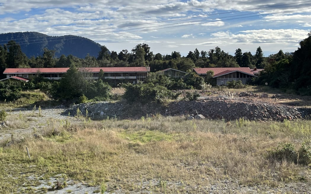 The rear of the abandoned Scenic Circle Mueller Wing at Franz Josef, looking from the point on the bank where the Waiho (Waiau) River broke through in March 2016, inundating the 1965-built complex, and the Westland District Council Franz Josef wastewater treatment station downstream.
