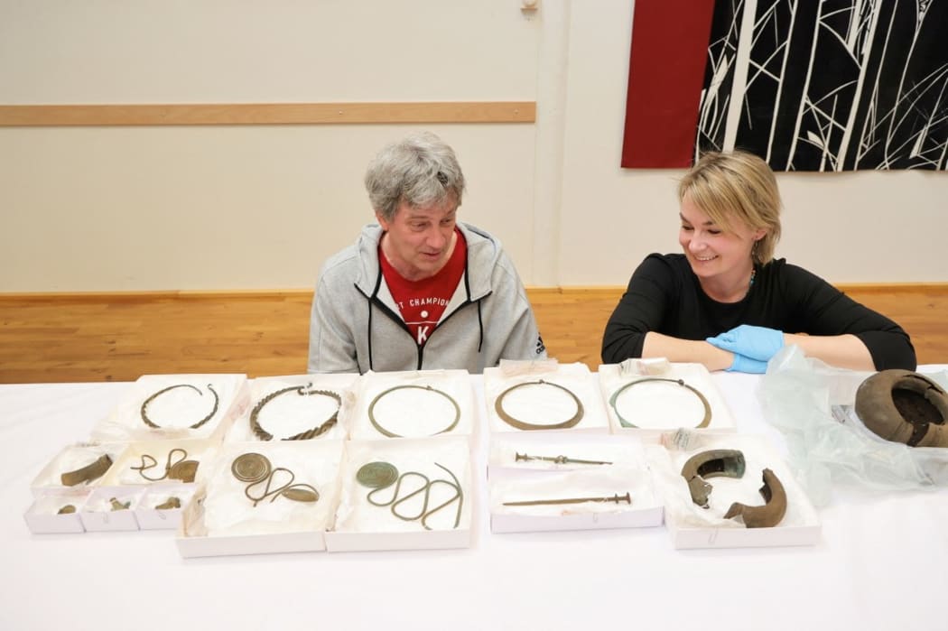Mats Hellgren, archaeologist, and Madelene Skogbert, curator, look at necklaces, foot rings, chains and other objects from the Late Bronze Age which have been found in an archaeological survey south of Alingsås shown in Gothenburg, Sweden, on April 29, 2021.