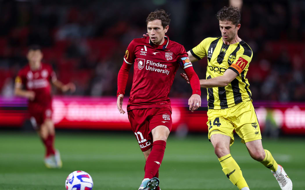 Craig Goodwin of Adelaide United is tackled by Alex Rufer of the Phoenix during the A-League Men's Elimination Final in Adelaide.