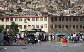 Afghan protesters from Hazara minority stand at the blast site after a suicide attack in Kabul, Afghanistan.