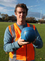 Geologist Ben Kennedy holds a sand-filled rubber ball that has just been fired over 80 metres by the trebuchet - it started spherical, and as it flew it flattened and became more tyre shaped